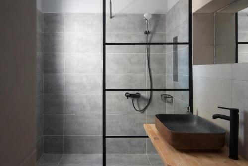 a bathroom with a shower with a sink at KYMA Seafront Exceptional 2BD house in Naousa in Naousa