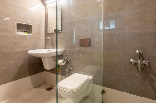 a bathroom with a toilet and a sink and a shower at Green Meadows Resort in Chennai
