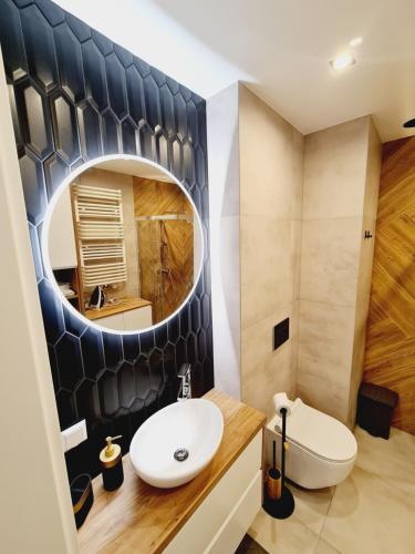 a bathroom with a sink and a mirror at Apartament Wałowa in Gdańsk
