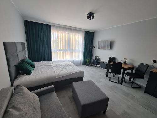a bedroom with a bed and a couch and a table at Apartament Wałowa in Gdańsk