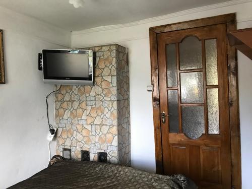 a room with a tv on the wall and a door at Підскельний in Yaremche