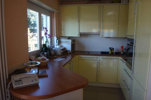 een keuken met gele kasten en een telefoon op een aanrecht bij Wohnung mit See Sicht in Carona in Carona