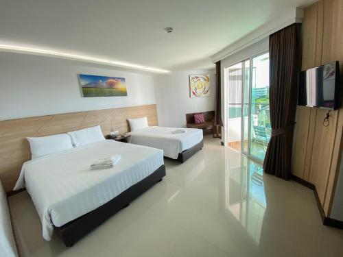 a hotel room with two beds and a television at Vareena palace hotel in North Pattaya