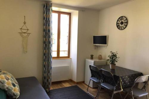 a living room with a table and chairs and a window at Chez Steph et Ben’s 5min de Meymac in Maussac