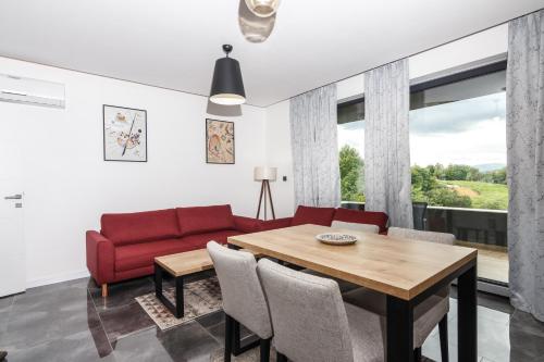 uma sala de estar com um sofá vermelho e uma mesa em Deluxe Feliciano Apartments em Visoko
