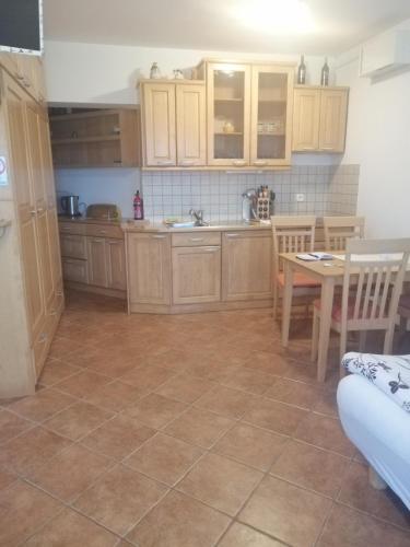 una cocina con armarios de madera, mesa y sillas en Julija Podkoren, en Kranjska Gora