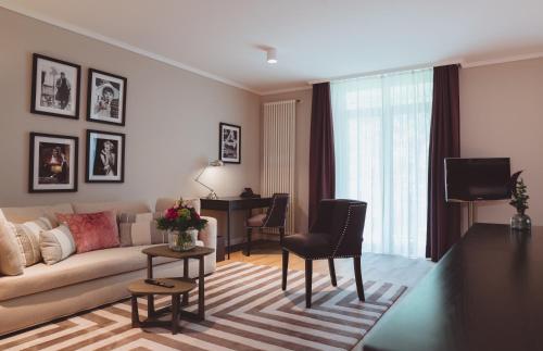 a living room with a couch and a table at VILA VITA Rosenpark in Marburg an der Lahn