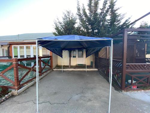 a blue umbrella sitting on a patio in front of a house at Студия 20 м3 in Orlovka