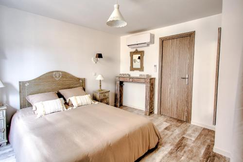 a bedroom with a large bed and a wooden door at L'Escapade à Lascaux in Montignac