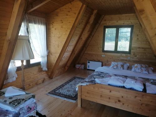 een slaapkamer met een bed in een blokhut bij Vikendica Ines in Nova Varoš