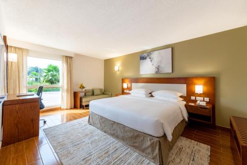 a large bedroom with a large bed and a television at Dhafra Beach Hotel in Jebel Dhanna