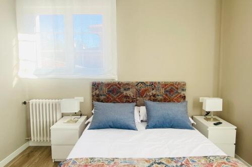 1 dormitorio con 1 cama con 2 mesitas de noche y 2 lámparas en Casa Vacacional Galiana, en Avilés