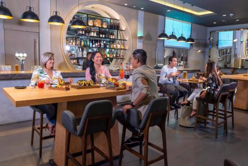 a group of people sitting at a table in a restaurant at Centro Capital Centre By Rotana in Abu Dhabi