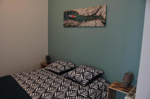 1 dormitorio con 1 cama y una pintura en la pared en nid douillet 4places 2lits cœur de ville logement Hote-Zen wifi, en Segré
