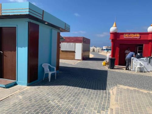 a man sitting outside of a red and blue building at Mohamed Afifi Stella Heights - Sidi Abdel Rahman - Families - 3 Bed rooms in El Alamein