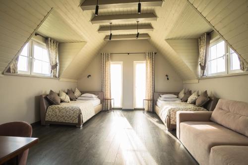 Pokój na poddaszu z 2 łóżkami i kanapą w obiekcie Publo Spa Hotel w mieście Vyshkove