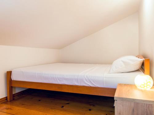 a small bedroom with a bed with white sheets at Green Home Apartments in Kotor