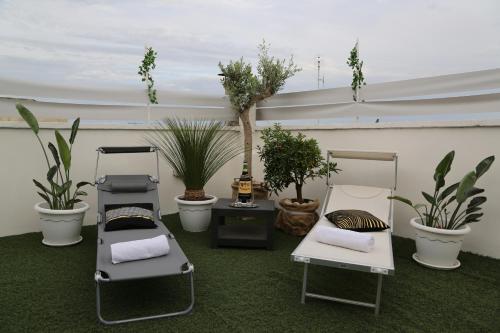 a room with three beds and potted plants on the floor at TERRAZZE BS in Rutigliano