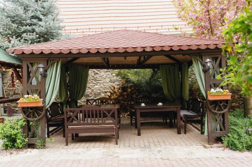 a wooden gazebo with chairs and a table at Pensiunea Grosspold in Miercurea Sibiului