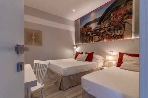 Habitación con 2 camas y una pintura en la pared. en Aquamarina, en La Spezia