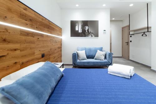 a bedroom with a blue bed and a chair at Hotel Portum in Giardini Naxos