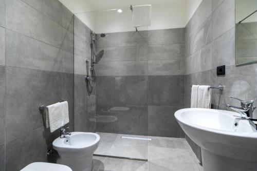 a bathroom with a toilet and a sink at Hotel Portum in Giardini Naxos