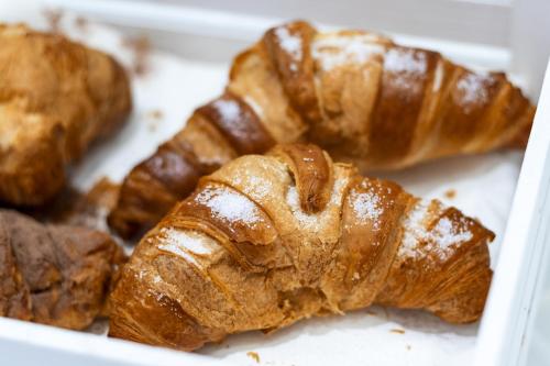 a white box filled with croissants and other pastries at Hotel Portum in Giardini Naxos