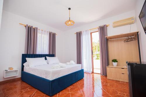 a bedroom with a blue bed and a window at Villa Gaudium in Vlorë