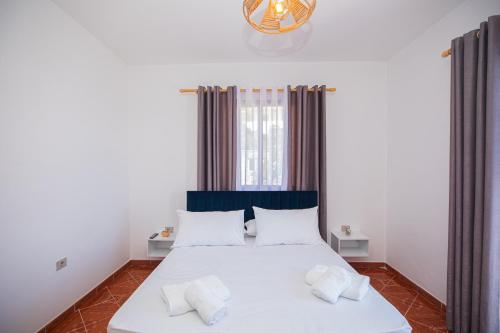 a bedroom with a white bed with two pillows at Villa Gaudium in Vlorë