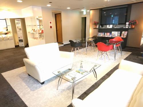 sala de estar con muebles blancos y mesa en Hotel Bougain Villea Sapporo en Sapporo