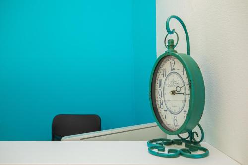 a green clock sitting on top of a table at Villa Gaudium in Vlorë