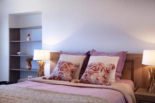 a bedroom with a bed with pillows and two lamps at Résidence de la Tour in Piana