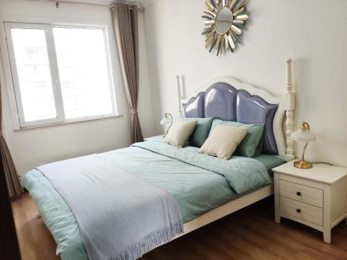 a bedroom with a blue bed with a mirror on the wall at Henan Luoyang·Henan University of Science And Technology· Locals Apartment 00150340 in Luoyang