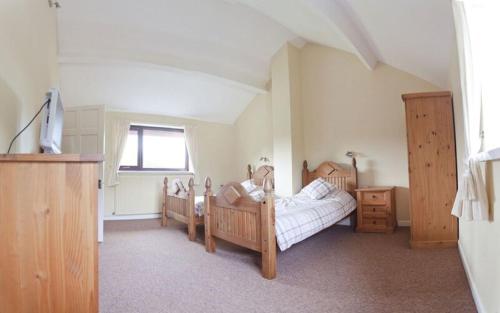 a bedroom with two beds and a tv in it at 3 Bed Cottage with Hot Tub & Near New Quay Wales in Llandysul
