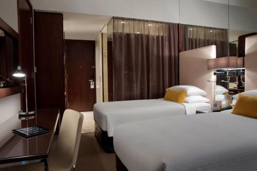 a hotel room with two beds and a table at Centro Capital Centre By Rotana in Abu Dhabi