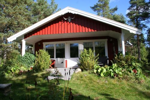 a small red and white house with a garden at Björsjödal Lake House's in Gothenburg