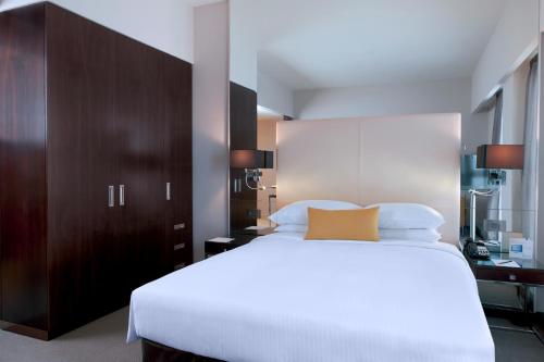 a bedroom with a large white bed and brown cabinets at Centro Capital Centre By Rotana in Abu Dhabi