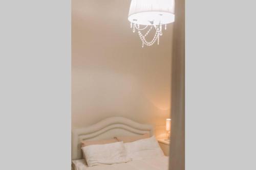 a bedroom with a bed and a chandelier at Debbie's House in Kalamata