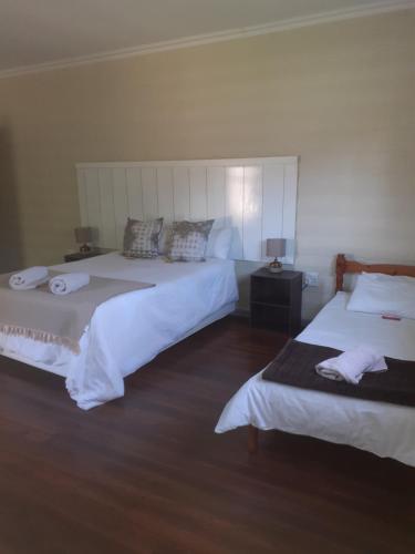 1 dormitorio con 2 camas y toallas. en Biesiesvlei 2, en Plettenberg Bay