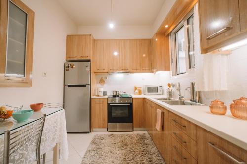 a kitchen with wooden cabinets and a stainless steel refrigerator at Debbie's House in Kalamata