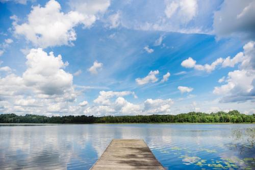 a dock on a lake with a cloudy sky at Viesu Sēta LOCU SALA in Krāslava