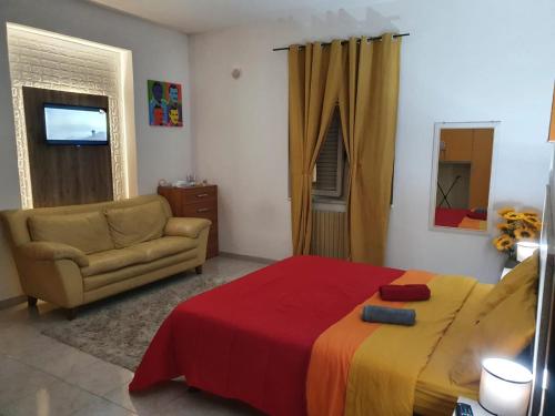 een slaapkamer met een bed, een bank en een televisie bij Sweet Home Montecristo Civico 1 in Vibo Valentia