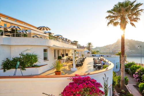 a hotel with a balcony with a palm tree at LH Pedraladda Resort in Castelsardo