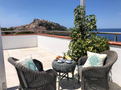 a balcony with chairs and a table with a view at LH Pedraladda Resort in Castelsardo
