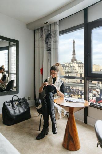 a woman sitting at a table with a view of the eiffel tower at Le Parisis - Paris Tour Eiffel in Paris