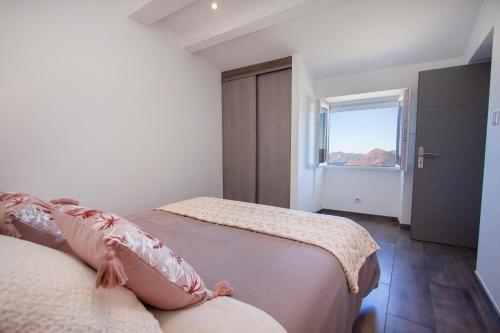 a bedroom with two beds and a window at Résidence de la Tour in Piana