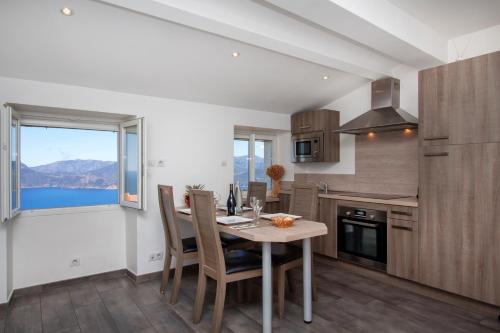 a kitchen with a table and chairs and a window at Résidence de la Tour in Piana