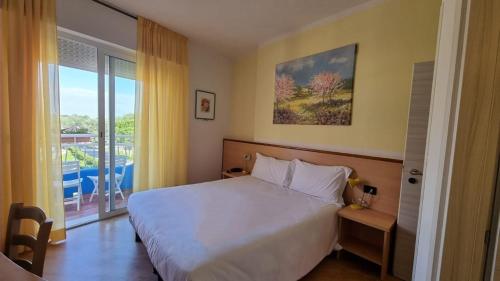 een slaapkamer met een bed en een groot raam bij Hotel Playa Blanca in Duna Verde