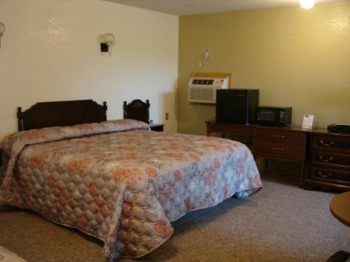 um quarto de hotel com uma cama e uma televisão em Nevada Inn em Nevada