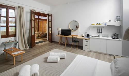 un soggiorno con cucina e tavolo di Syros Wellness Luxury Suites a Finikas